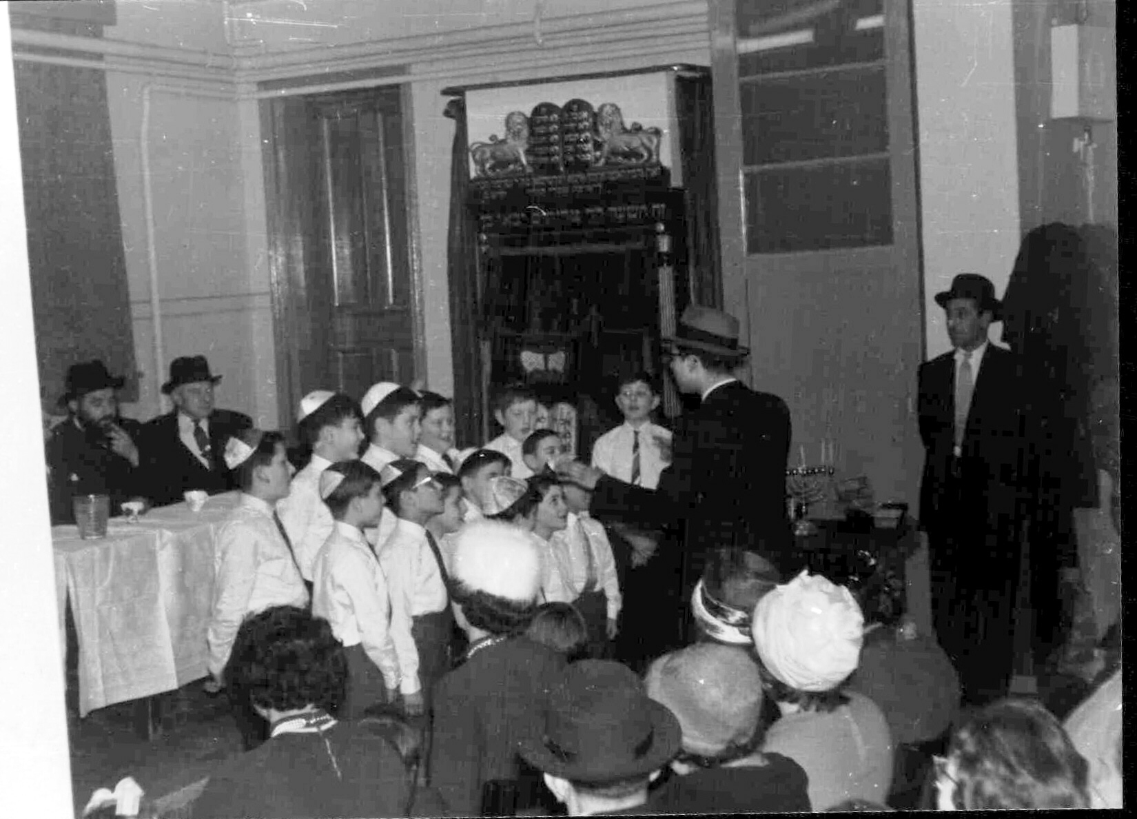 Rabbi S Halstuck of Commercial Road Great synagogue listening to the synagogue's boys choir, early 1950s